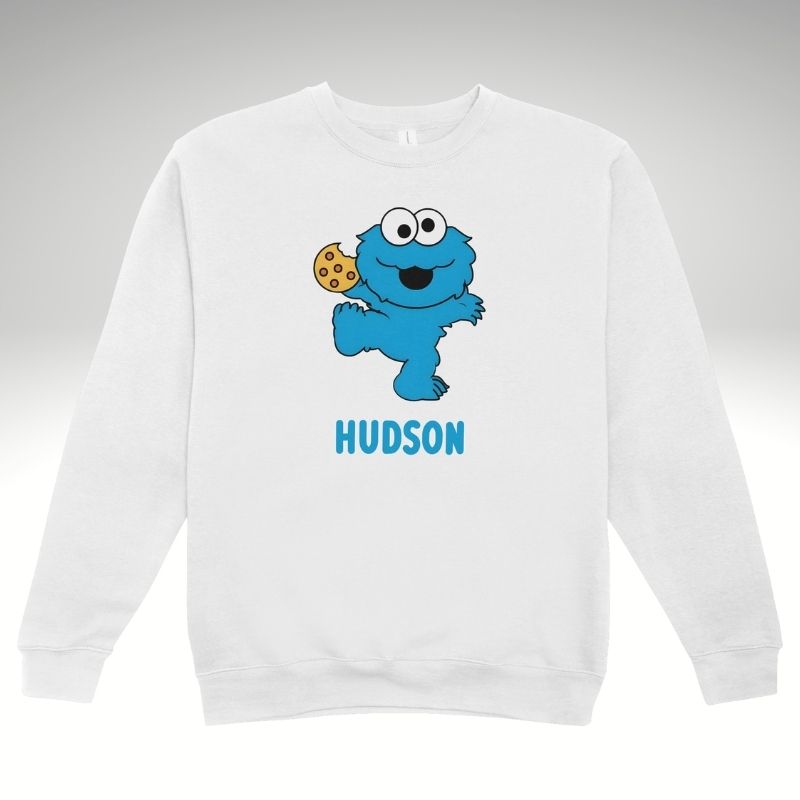 White sweatshirt with Cookie Monster design and 'Hudson' text on a grey background