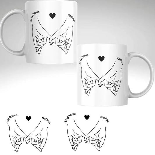 Personalised Couples Mug – Linking Fingers with Names. Two white mugs with black line art of hands holding hearts and names 'Stephanie' and 'Nathan'.